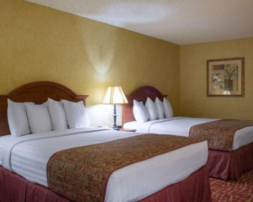 a hotel room with two beds and a lamp at Rodeway Inn Columbia Mall Loop in Grand Forks