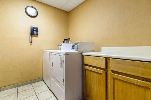 a laundry room with a refrigerator and a clock on the wall at Quality Inn Lumberton North in Lumberton
