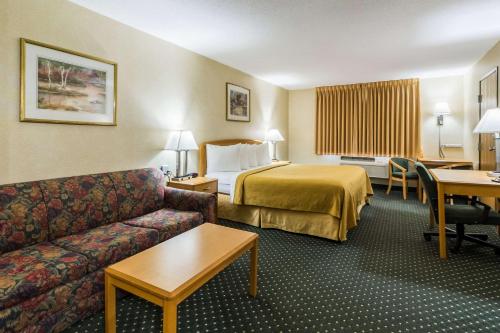 a hotel room with a bed and a couch at Quality Inn Columbia Mall in Grand Forks