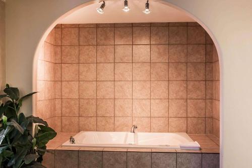 y baño con bañera y pared de azulejos. en Sleep Inn & Suites Conference Center and Water Park en Minot