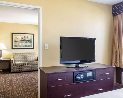 a hotel room with a flat screen tv on a dresser at MainStay Suites Minot in Minot