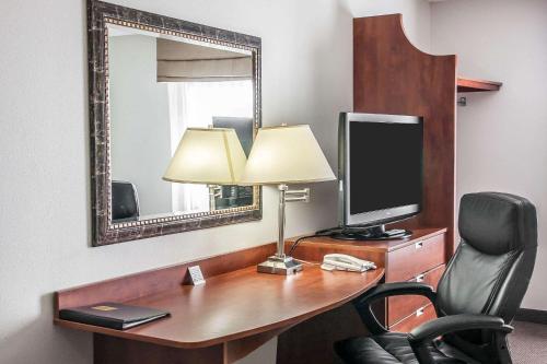 a desk with a television and a lamp and a chair at Sleep Inn & Suites Conference Center and Water Park in Minot