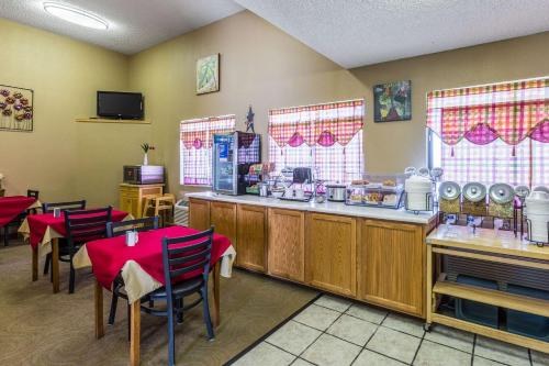 a restaurant with a counter and tables and chairs at Quality Inn Scottsbluff in Scottsbluff