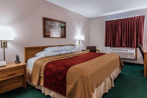 a hotel room with a large bed and a window at Rodeway Inn in Holdrege