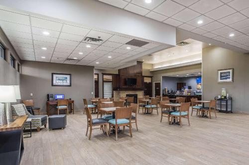 a restaurant with wooden tables and chairs and a bar at Comfort Inn SW Omaha I-80 in Omaha