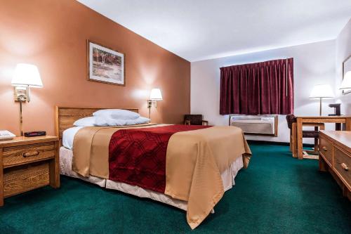 a hotel room with a large bed and a window at Rodeway Inn in Holdrege