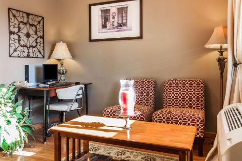 a living room with a desk and chairs and a table at Rodeway Inn in Holdrege