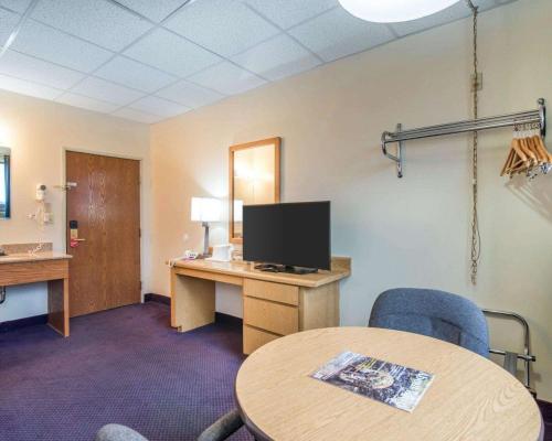a room with a desk with a tv and a table at Econo Lodge Manchester in Manchester