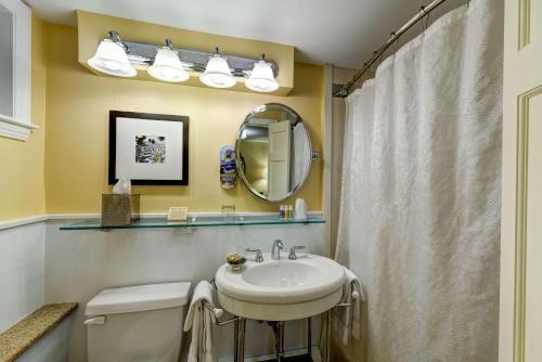 W łazience znajduje się umywalka, toaleta i lustro. w obiekcie Port Inn and Suites Portsmouth, Ascend Hotel Collection w mieście Portsmouth