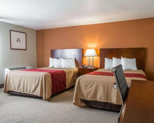 um quarto de hotel com duas camas e uma secretária em Econo Lodge Lakes Region em West Ossipee