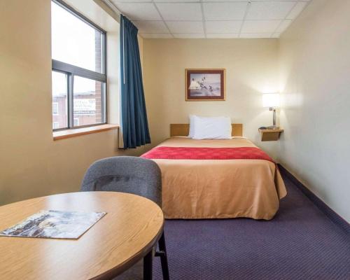 a hotel room with a bed and a table at Econo Lodge Manchester in Manchester