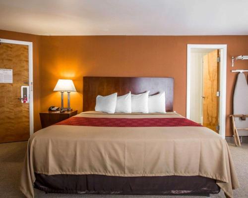 a hotel room with a large bed with white pillows at Econo Lodge Lakes Region in West Ossipee