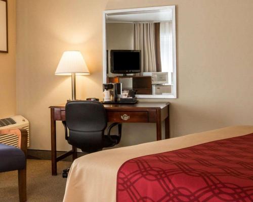 a hotel room with a bed and a desk with a computer at Econo Lodge Lakes Region in West Ossipee