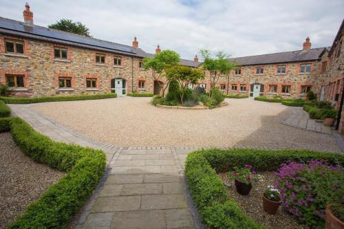 ein großes Backsteingebäude mit einem Innenhof mit Pflanzen in der Unterkunft Decoy Country Cottages in Navan