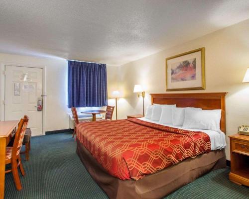 pokój hotelowy z łóżkiem, stołem i krzesłami w obiekcie Econo Lodge w mieście Somers Point