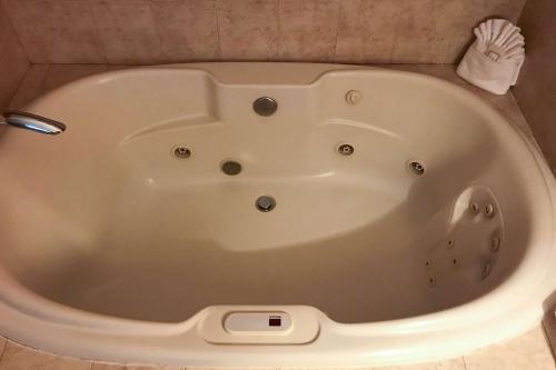 a white bath tub in a bathroom with a brush at Clarion Hotel & Conference Center in Toms River
