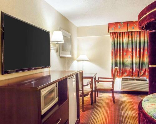 a hotel room with a flat screen tv and a living room at Days Inn by Wyndham Jersey City in Jersey City