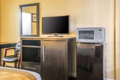 a room with a tv and a microwave and a mirror at The Boards AC in Atlantic City