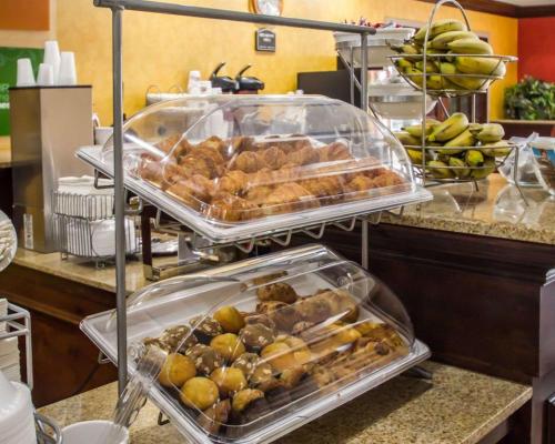 a buffet with several trays of food on a counter at Quality Suites NYC Gateway in North Bergen