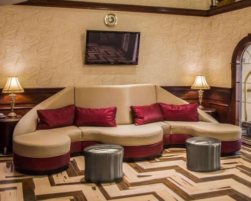 a living room with a couch and red pillows at Quality Suites NYC Gateway in North Bergen