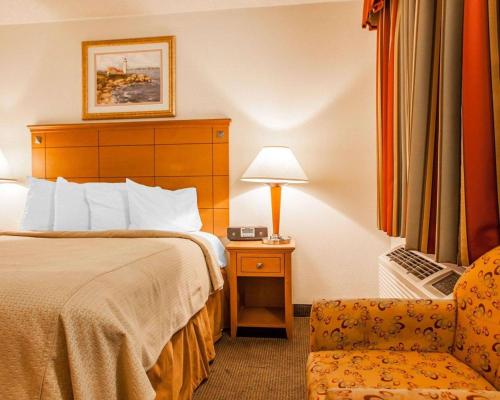 a hotel room with a bed and a chair at Rodeway Inn Point Pleasant Beach in Point Pleasant