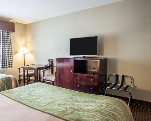 ein Hotelzimmer mit einem Bett und einem Flachbild-TV in der Unterkunft Avon Hotel - Toms River in Toms River