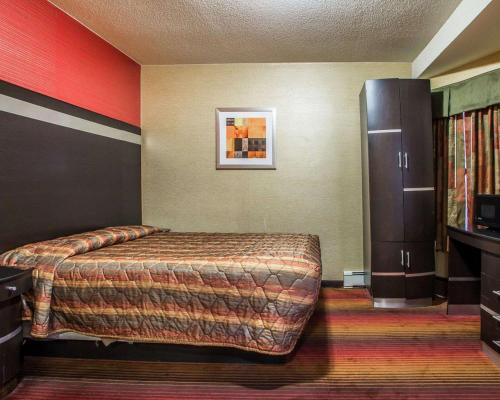 a hotel room with a bed and a refrigerator at Rodeway Inn in Belleville