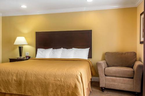 a hotel room with a bed and a chair at Quality Inn near Mountain Creek in Vernon