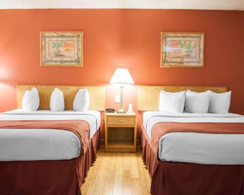 2 letti in una camera d'albergo con pareti arancioni di Econo Lodge Old Town ad Albuquerque