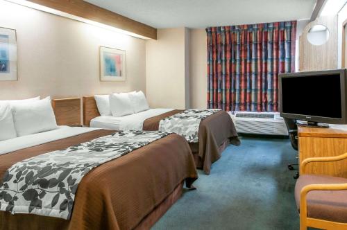 una camera d'albergo con due letti e una TV a schermo piatto di Sleep Inn University a Las Cruces