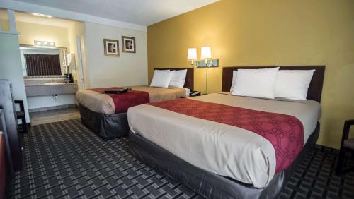 a hotel room with two beds and a window at Econo Lodge Downtown Albuquerque in Albuquerque