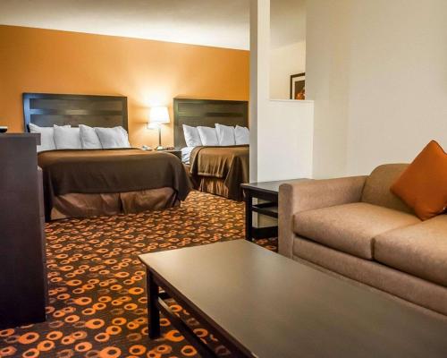 サンタフェにあるEcono Lodge Inn & Suitesのベッド2台とソファが備わるホテルルームです。