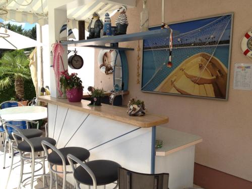 a bar in a restaurant with chairs and a table at Happy Lake by Thomas Strugger in Krumpendorf am Wörthersee
