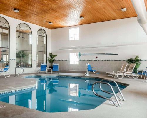 a swimming pool with blue chairs and a wooden ceiling at Quality Inn & Suites in Albuquerque