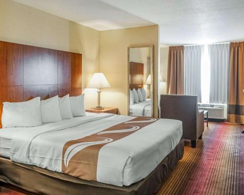 a hotel room with a large bed and a mirror at Quality Inn & Suites Albuquerque West in Albuquerque