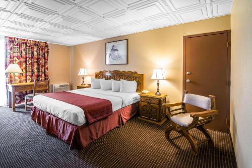 a hotel room with a large bed and a chair at Quality Inn in Taos