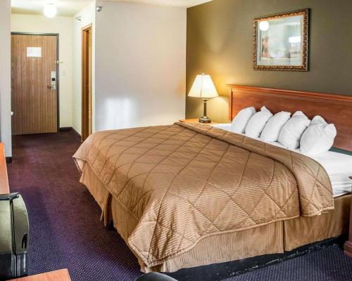 a hotel room with a large bed with white pillows at Rodeway Inn Espanola in Espanola