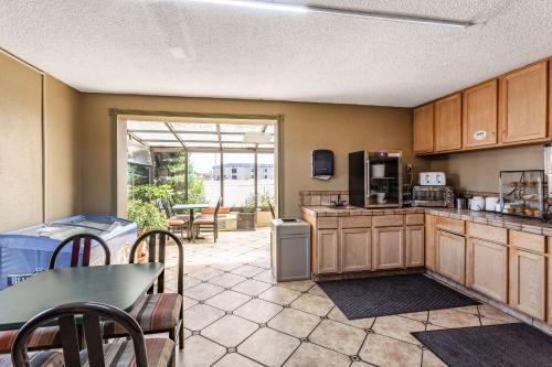 法明顿Rodeway Inn Farmington的配有木制橱柜、桌子和椅子的厨房