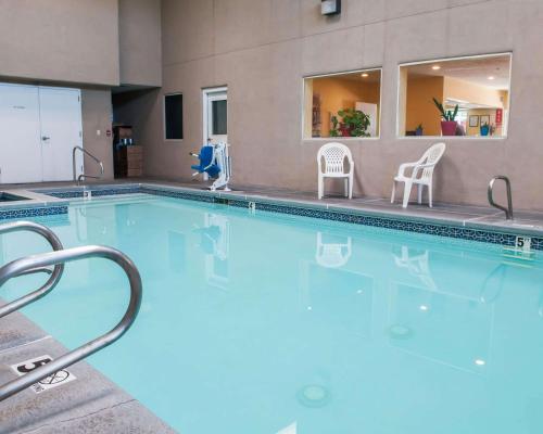 a large swimming pool with two chairs in a building at Econo Lodge Old Town in Albuquerque