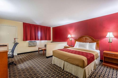 Habitación de hotel con cama y pared roja en Econo Lodge Santa Rosa, en Santa Rosa