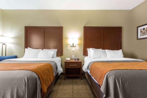 a hotel room with two beds with orange sheets at Comfort Inn & Suites in Deming
