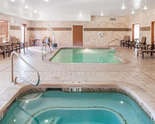 a pool in a hotel with tables and chairs at Comfort Suites in Roswell
