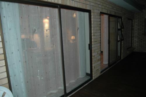 a screened in porch with sliding glass doors at Bon A Vie Self-catering and b&b Gonubie Full Solar Power, no load shedding! in Gonubie