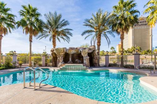 einen Pool mit einem Wasserfall und Palmen in der Unterkunft Comfort Inn & Suites Henderson - Las Vegas in Las Vegas