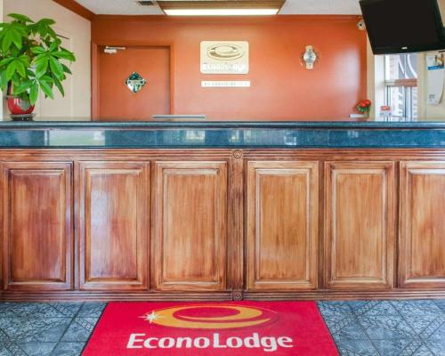 a bar with wooden cabinets and a red carpet at Econo Lodge Hobbs in Hobbs