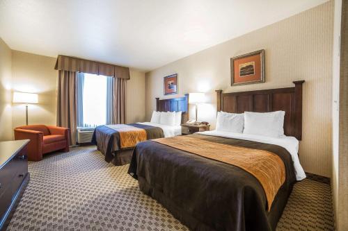 a hotel room with two beds and a chair at Comfort Inn & Suites Henderson - Las Vegas in Las Vegas