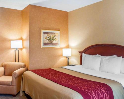 a hotel room with a bed and a chair at Quality Inn Near Walden Galleria Mall in Cheektowaga