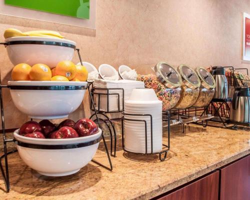 a bunch of bowls of fruit on a counter at Quality Inn Near Walden Galleria Mall in Cheektowaga