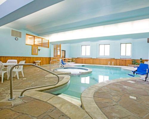 a large swimming pool with chairs and a table at Rodeway Inn Lake Placid in Lake Placid