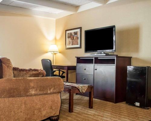 a living room with a tv and a couch and a chair at Quality Inn Buffalo Airport in Cheektowaga